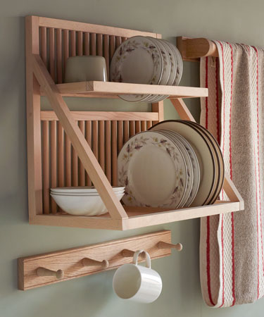 Wall mounted plate rack being used to store plate, bowls and cups